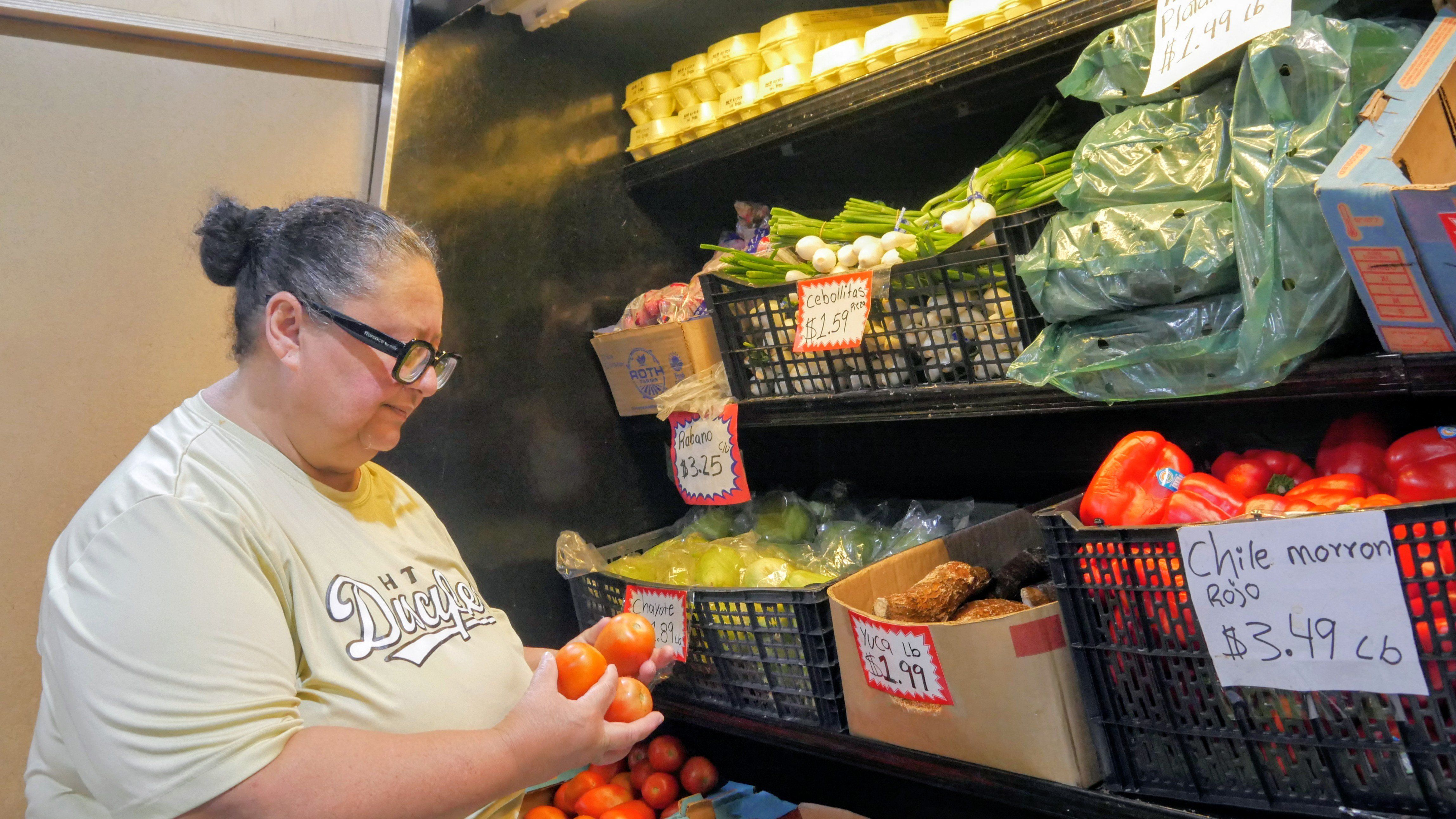Ada Torres holds tomatoes while shopping for produce in Cleveland, Texas, about 45 miles northeast of Houston. - AP