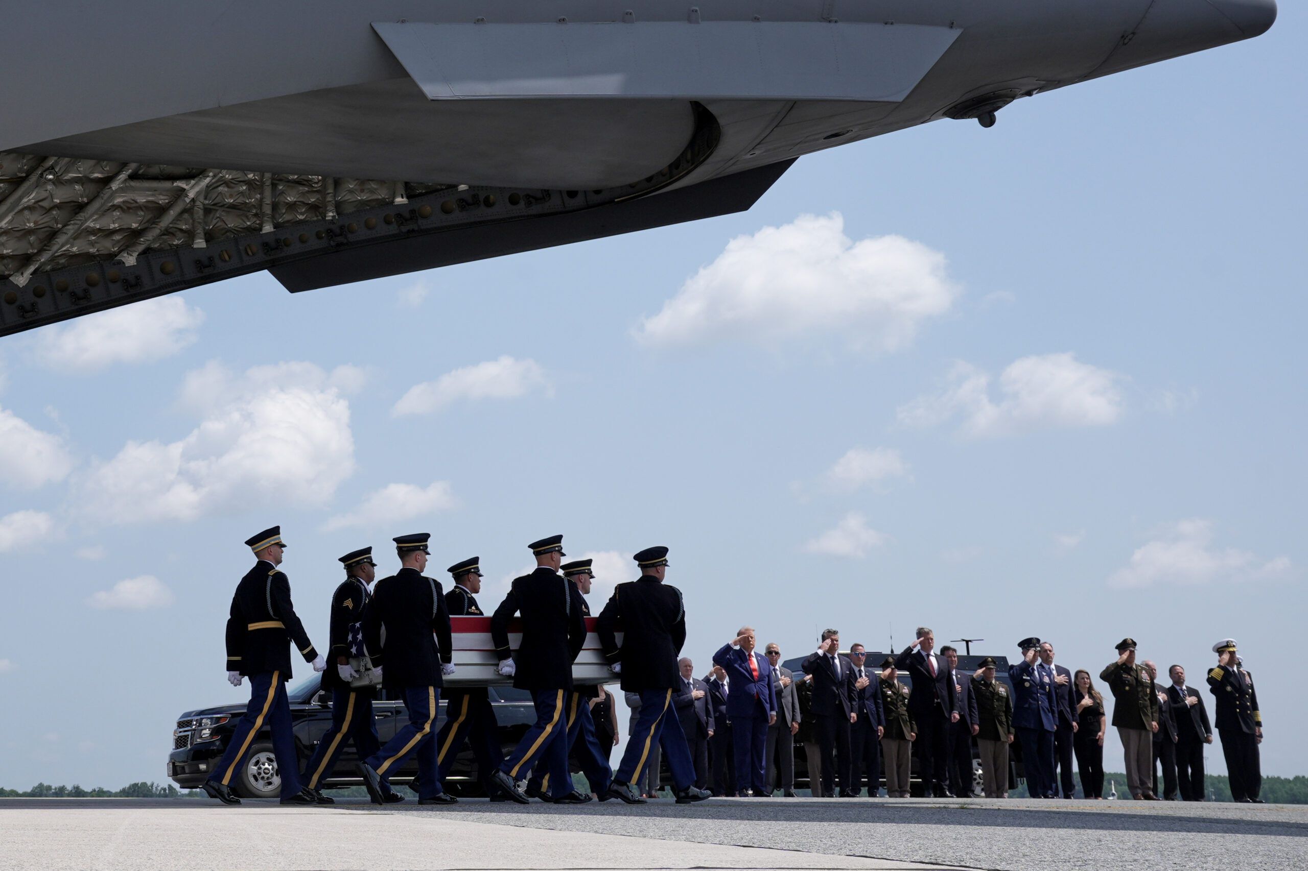 President Donald Trump and Defense Secretary Pete Hegseth salute as a U.S. Army carry team moves a transfer case containing the remains of Sgt. Angel S. Rampersad at Dover Air Force Base, Delaware. - AP Photo/Matt Rourke