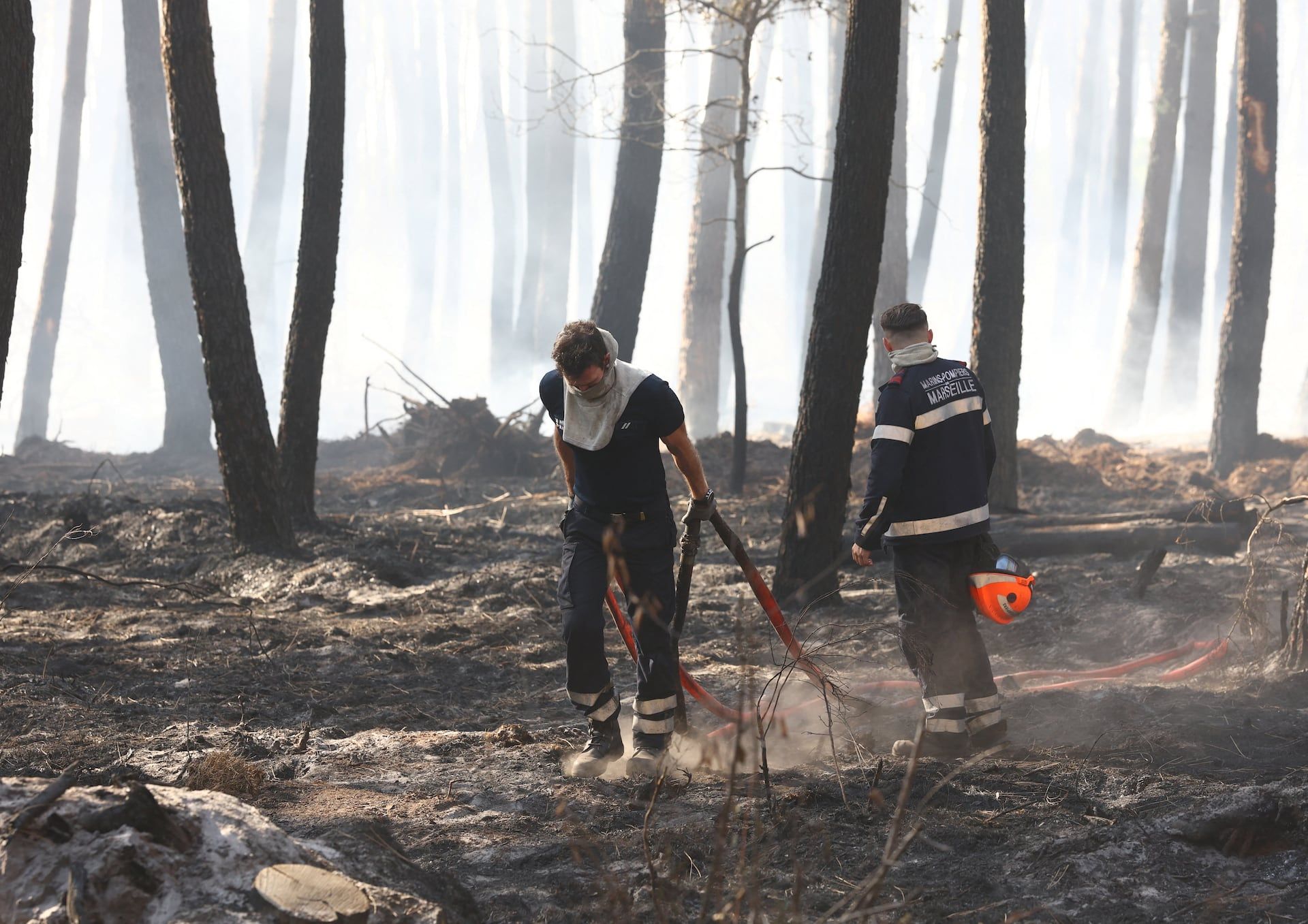 Firefighters walk in a burnt forest amid drought conditions following a heatwave and water shortages across much of France, in Lanton, Gironde, France, July 28, 2026. - REUTERS/Yves Herman