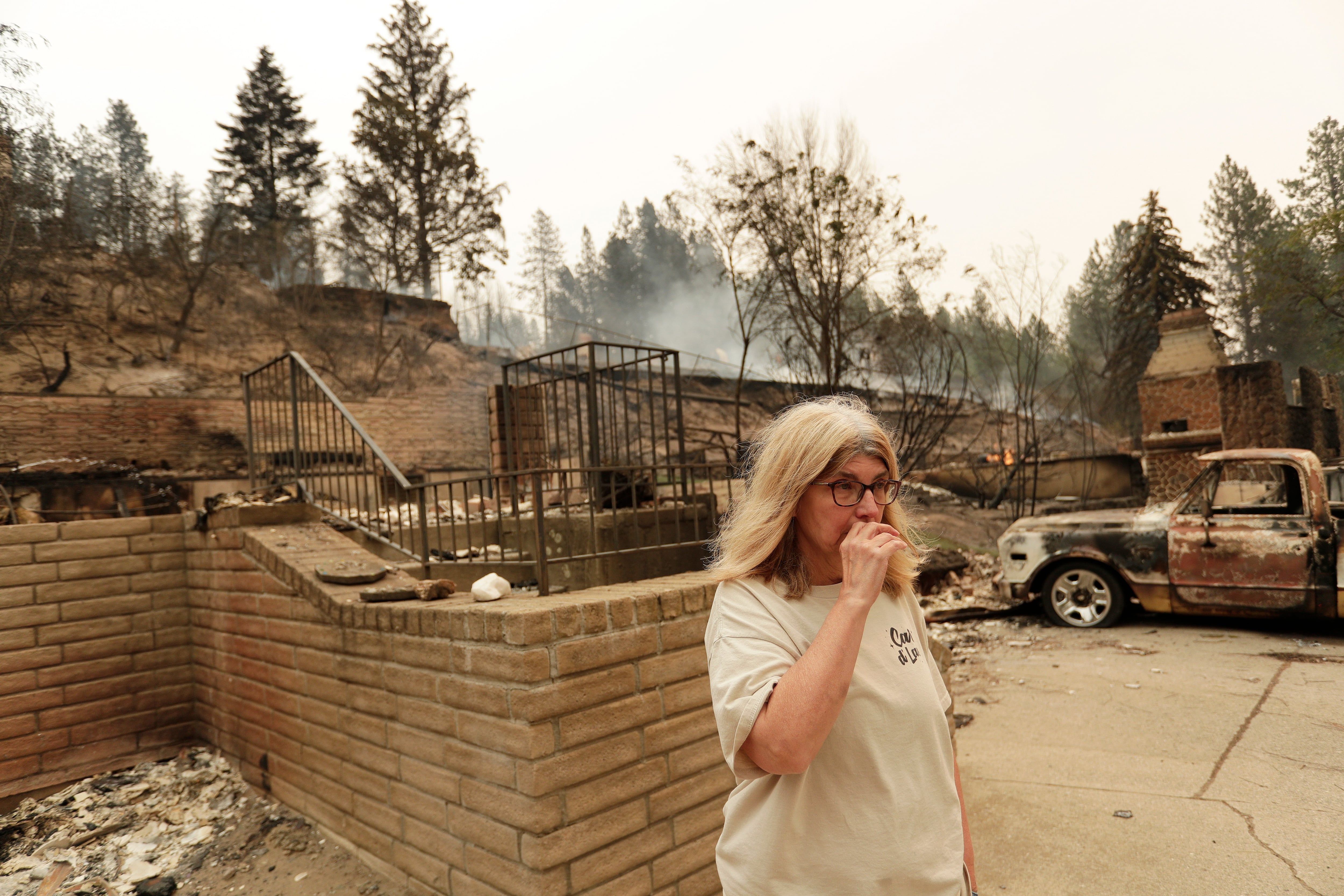 Kimberley Sather stands at the duplex she rents on W. Indian Trail Rd. after it burned in a wildfire in Spokane, Wash., Sunday, Aug. 2, 2026. - AP Photo/Young Kwak