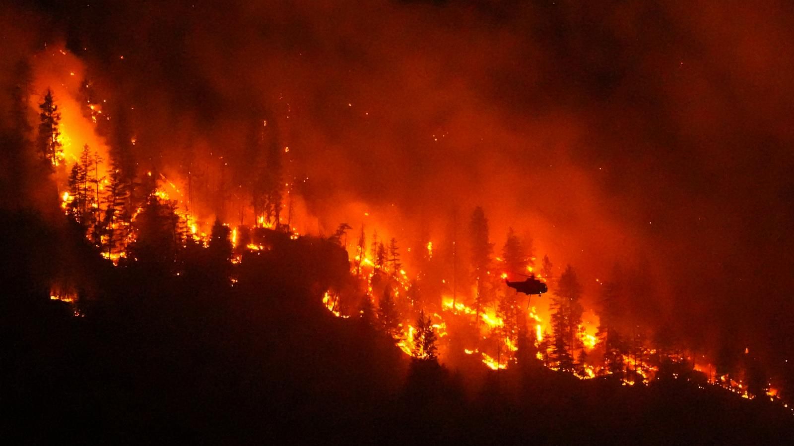 A helicopter conducting night operations prepares to drop water on the Quilpituk Creek wildfire near Fintry, British Columbia, on Aug. 3, 2026. - Darryl Dyck/The Canadian Press via AP