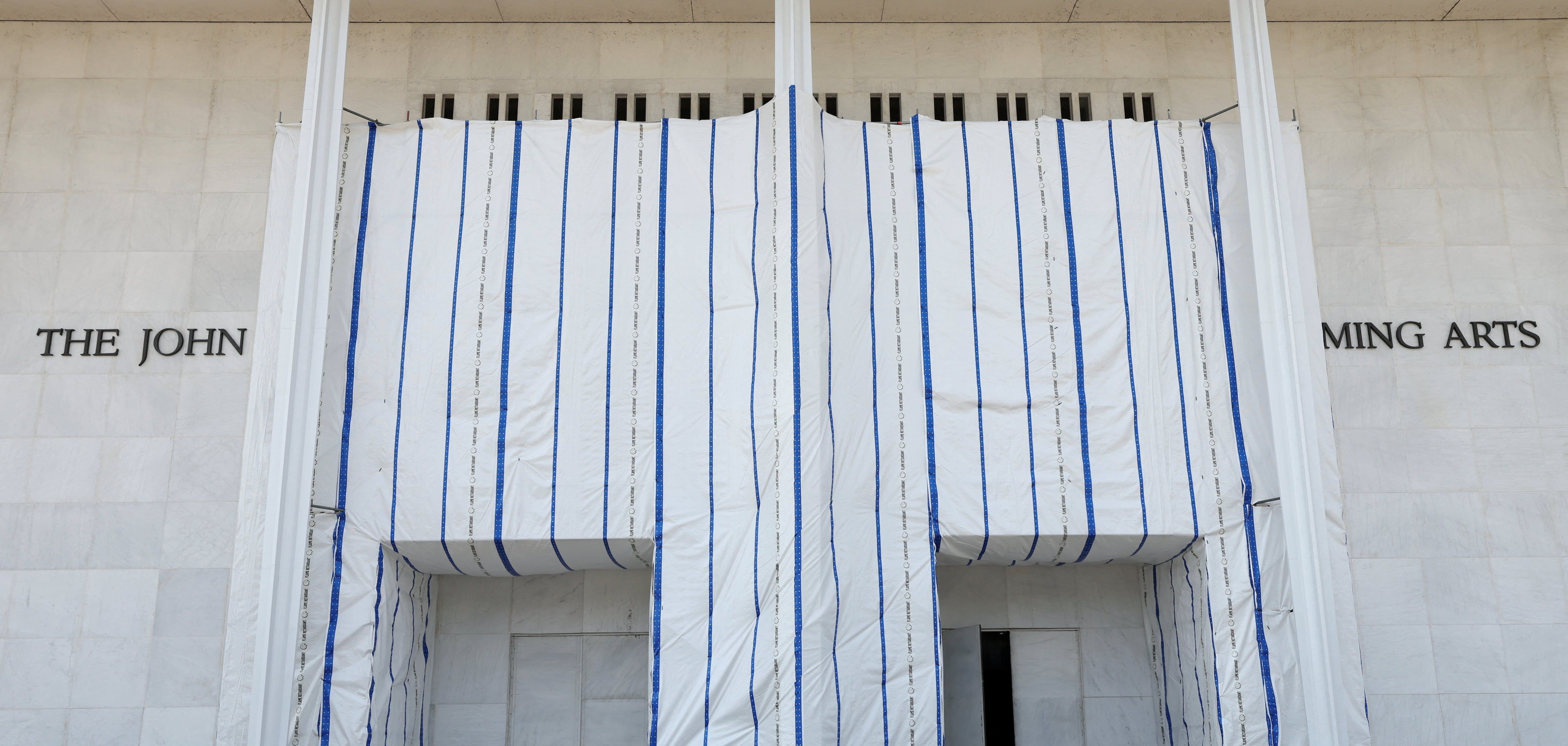Plastic sheeting remains in place over words at the main entrance to the John F. Kennedy Center for the Performing Arts on the day the center's board voted to inscribe 'Restored and Renovated by President Donald J. Trump' onto the building, in Washington, D.C., Aug. 13. - theglobeandmail.com