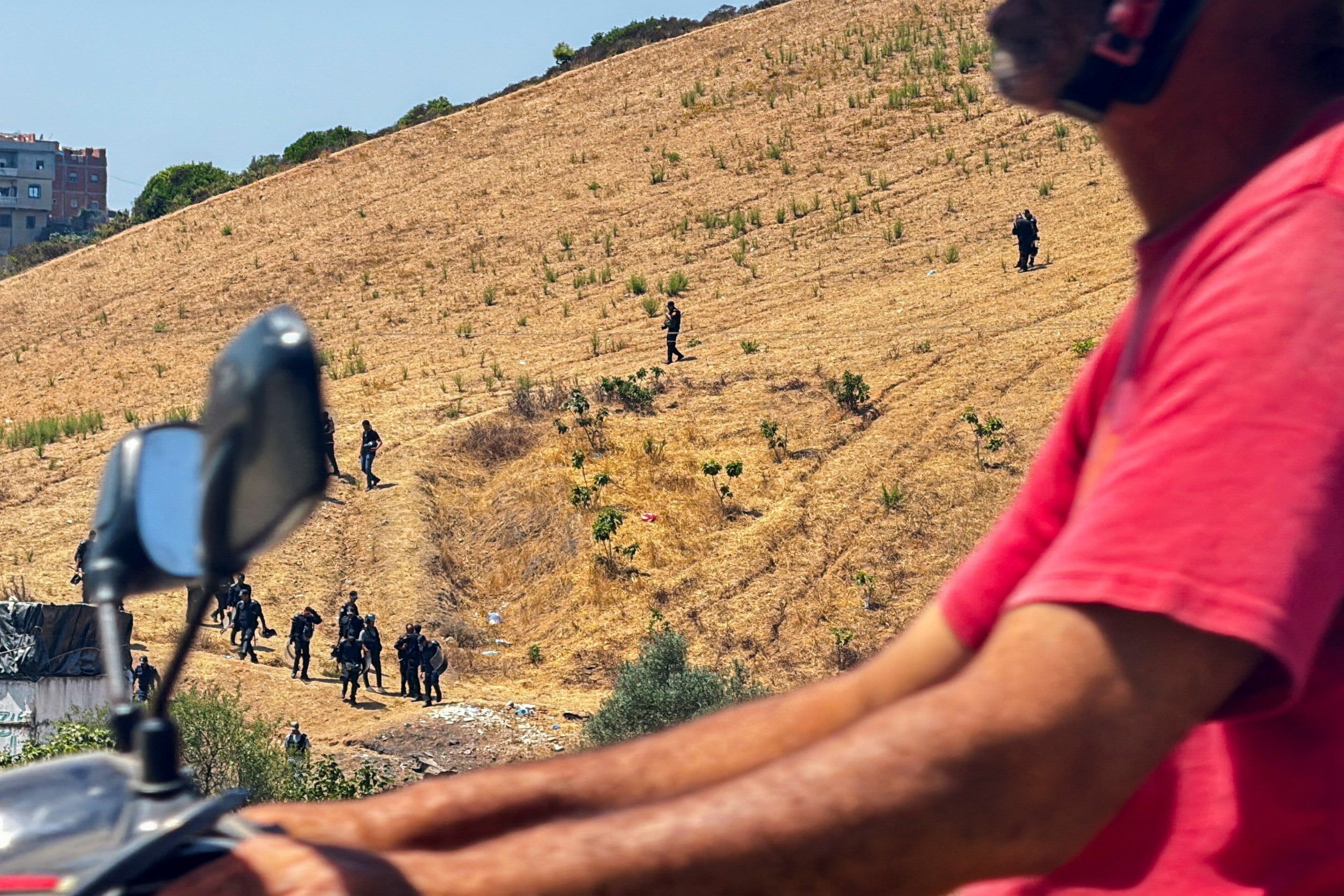 Moroccan security personnel search a hillside during an operation to locate migrants potentially attempting to cross irregularly into the Spanish enclave of Ceuta, in Fnideq, Morocco, August 15, 2026. - REUTERS/Maria Alejandra Cardona