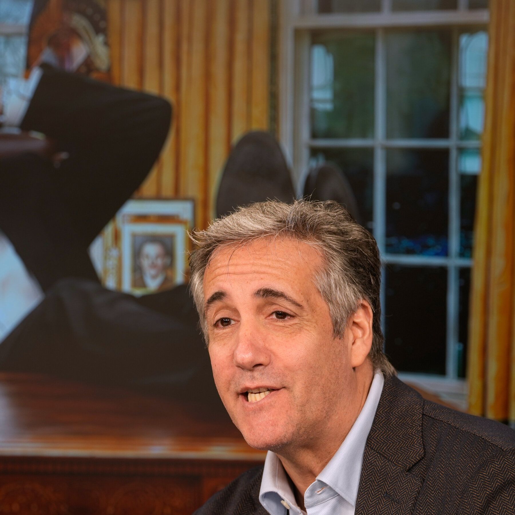 Michael Cohen in front of promotional material for his new radio show, which is meant to look like him in the Oval Office, during a news conference in New York last month. - nytimes.com