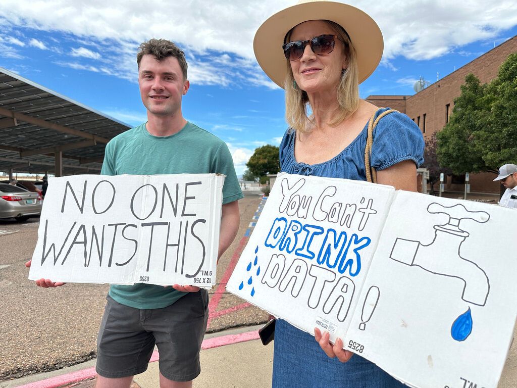 Jacob Weinreich and his mother Sharon Metcalf protest the Project Jupiter data center during a demonstration in Santa Fe, N.M., Friday, Aug. 21, 2026. - AP Photo/Susan Montoya Bryan